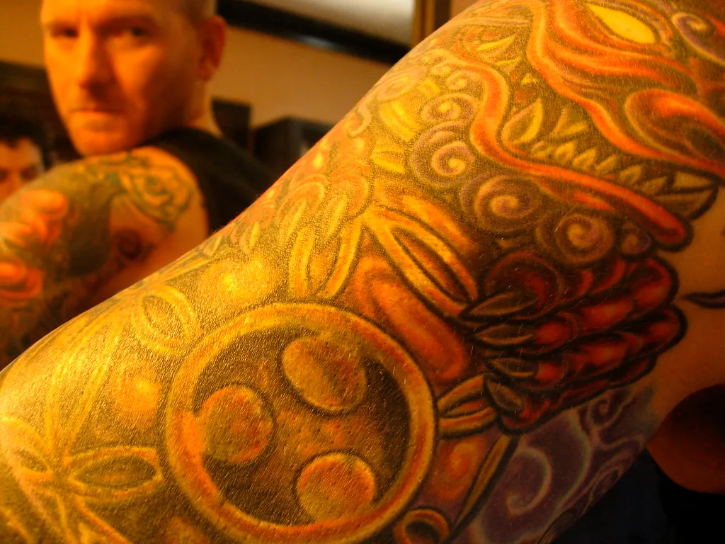 Detalle de manga tatuada en color naranja